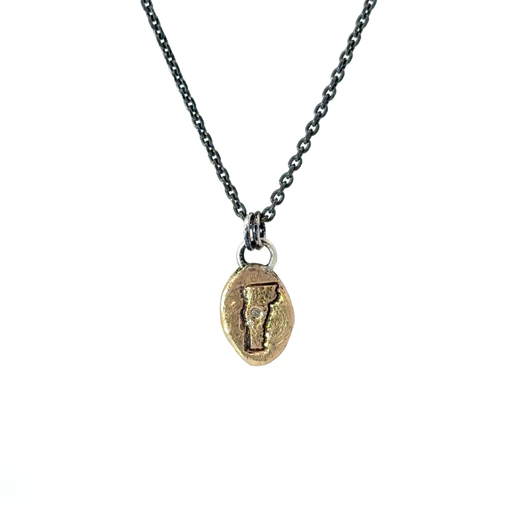 Necklace with a gold pendant featuring vermont with a diamond on the mad river valley