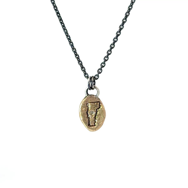 Necklace with a gold pendant featuring vermont with a diamond on the mad river valley
